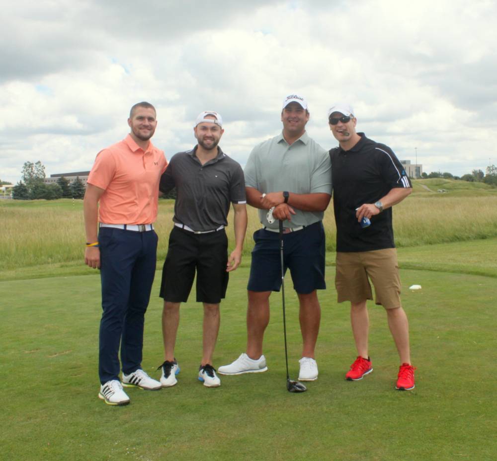 4 men ready to play on course